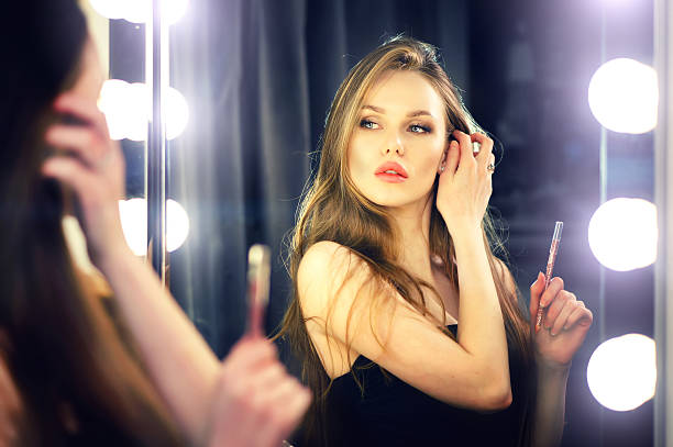 istock Woman looking into makeup mirror at herself. 585153408
