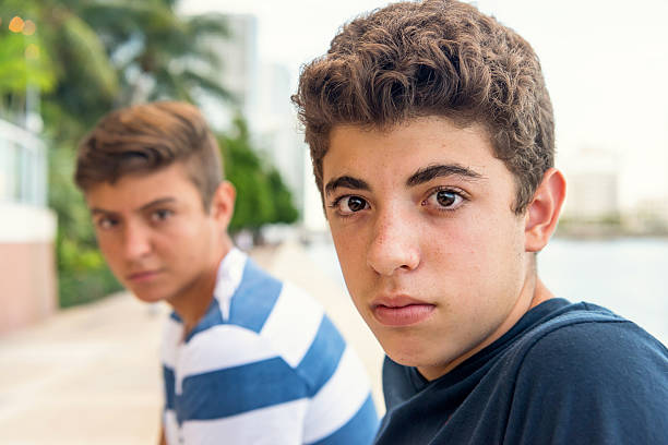 friendship: two overweight teenage boys in front of their school