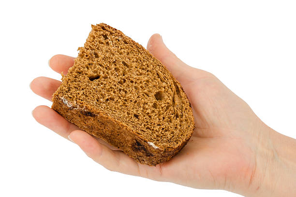 istock Female hand holds a slice of bread, isolated on white 585160132