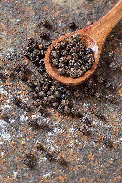 Peppercorns in wooden spoon Peppercorns in wooden spoon on texture background acrid taste stock pictures, royalty-free photos & images