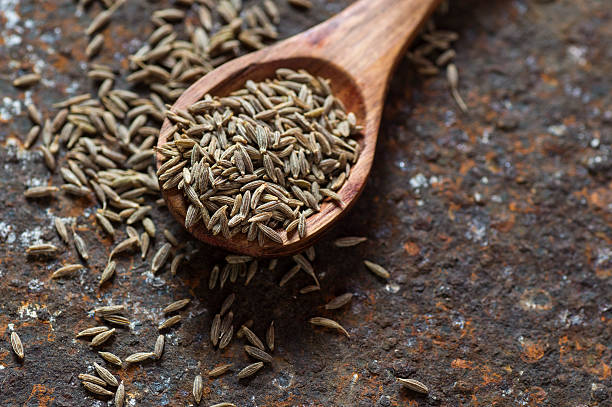 Cumin seeds in wooden spoon stock photo