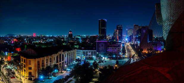 Mexico City, Mexico – March 2, 2014: Downtown Mexico City skyline at night from top of the revolution monument, front left the jai alai old building