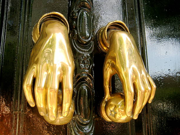 istock Ornate gold hand door knockers 585166112