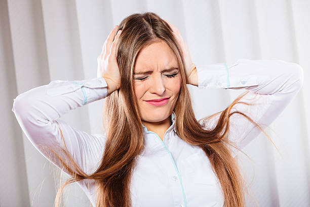 istock stressed woman in white shirt with headache 585166668