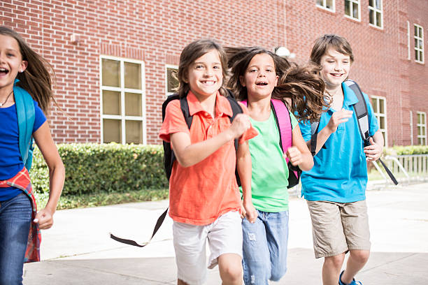 istock Elementary-age children, friends run on school campus. 585166754