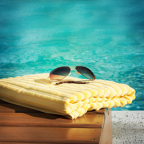 istock towel lying on a lounger beside the swimming pool 585167584