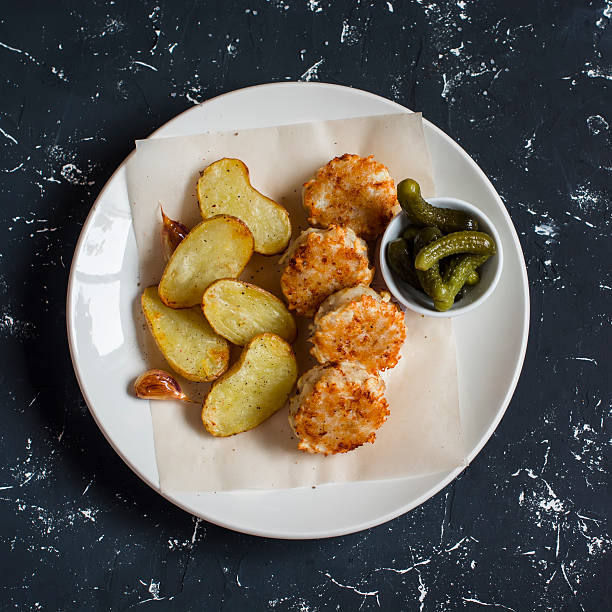 istock Fish balls and baked potatoes on light plate 585169972