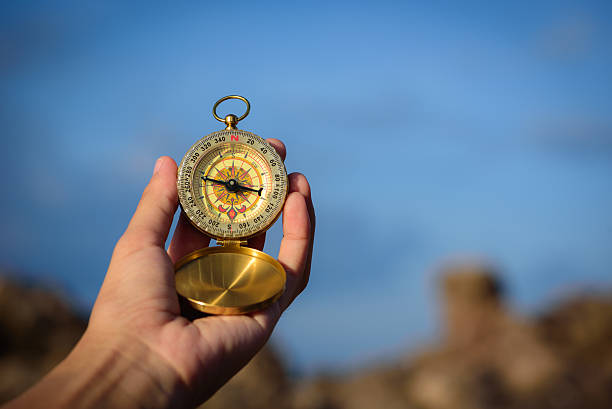 istock Compass in the hand on the nature background. 585170948