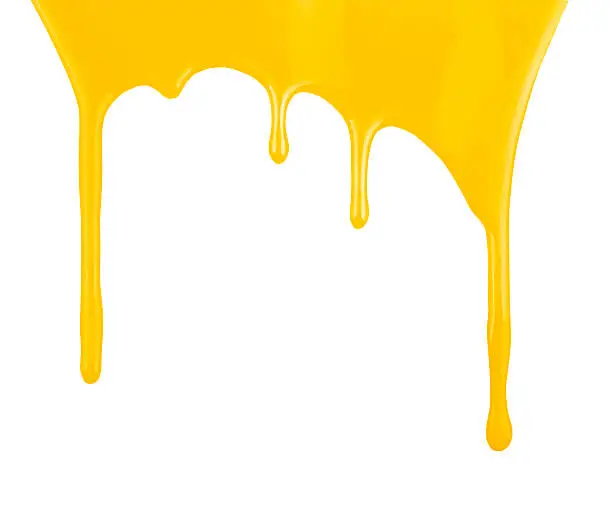 Photo of Yellow paint dripping isolated on white background