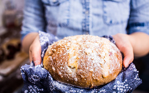 istock Holding Freshly Baked Loaf Of Bread 585172432