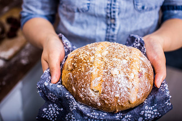 istock Holding Freshly Baked Loaf Of Bread 585172550