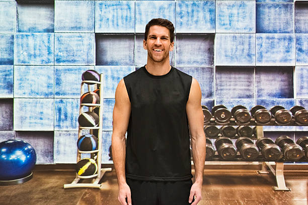 istock Smiling muscular man standing in gym 585175198