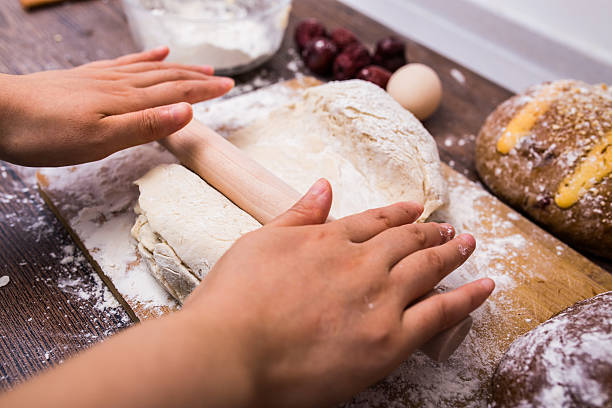 istock Making dough by female hands on wooden table 585175652