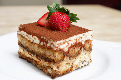 An Italian dessert consisting of layers of sponge cake soaked in coffee and brandy or liquor with powdered chocolate and mascarpone cheese.