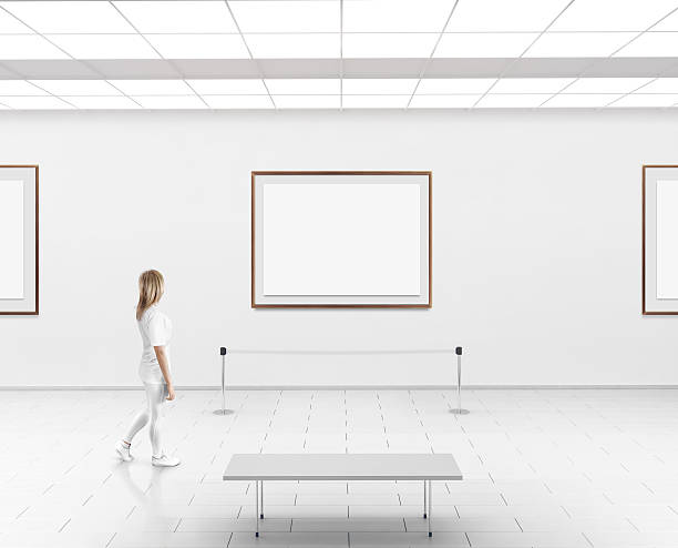 frau zu fuß in museumshalle leere wand mit rahmen - canvas artists canvas white frame stock-fotos und bilder