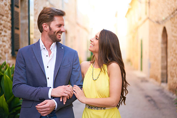 feliz mujer joven y hombre caminando en la ciudad - bien vestido fotografías e imágenes de stock