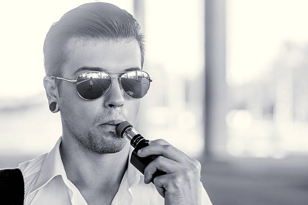 istock Young man smoking electronic cigarette outdoors 585183790