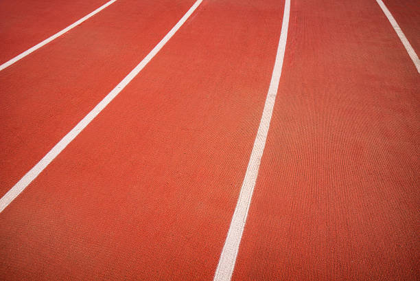 Red running track with white stripes in stadium for athlete, jogging, relax, walk and running