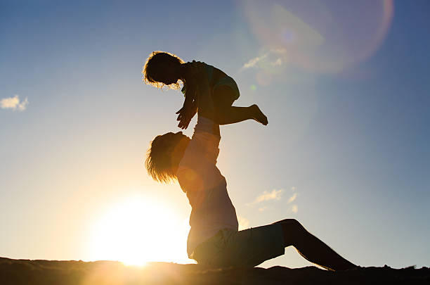 istock Father and little daughter playing silhouettes at sunset 585186904