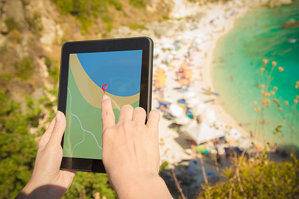 istock Female holding digital tablet with gps navigation above the beach 585187694