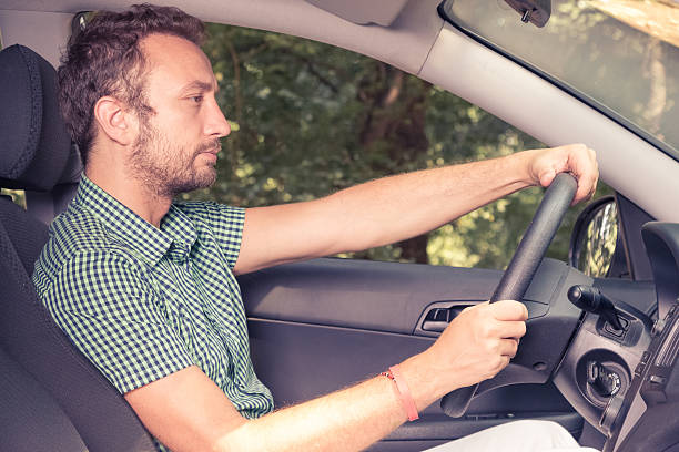 istock Side view of young man driving a car 585188178