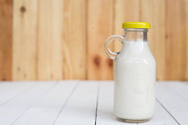 istock Bottle of fresh milk on wooden table. 585193062
