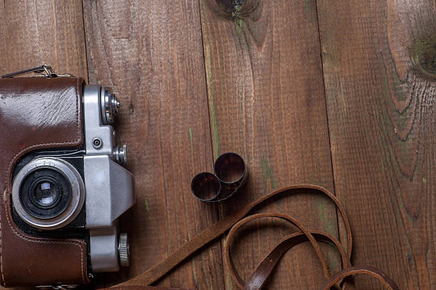 istock Old retro camera on vintage wooden boards abstract background. 585282304