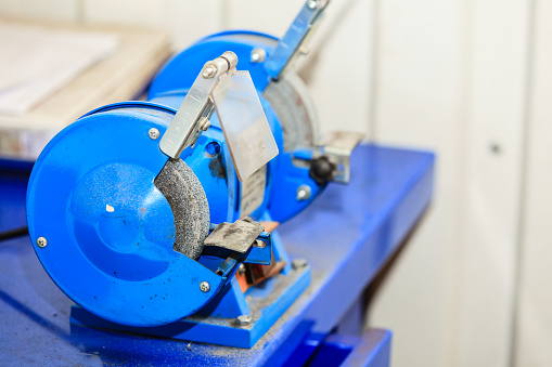 Blue bench grinder, electric tool in workshop,