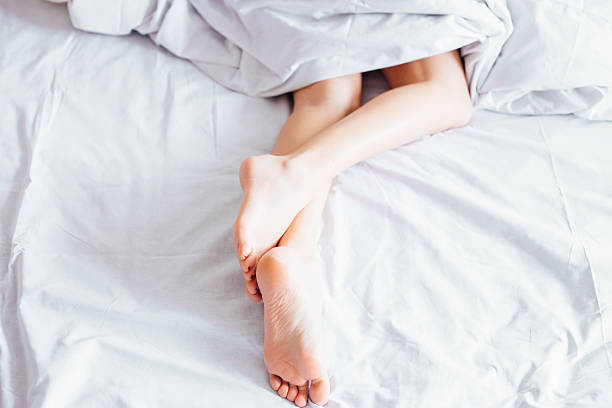 istock Woman legs in bed 585286976
