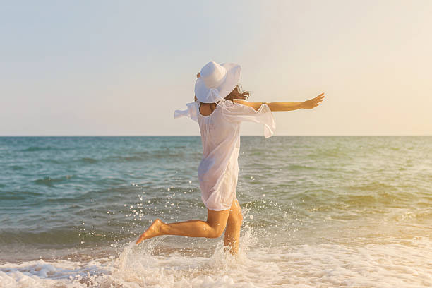 istock Casually Dressed Young Woman Running Along Beach 585290910