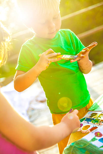 istock Boy and  girl draw on a table outdoors 585292842