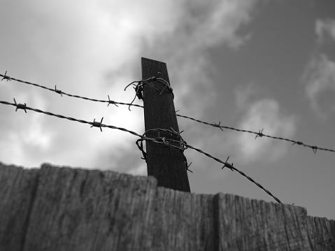 Streetlight on the electrified fence and barracks of the prisoners of the concentration camp.