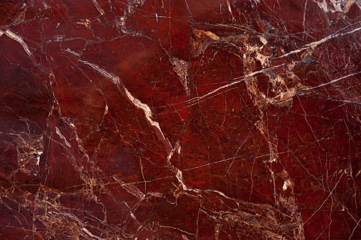 Red marble onyx texture with brown and white stripes and cracks
