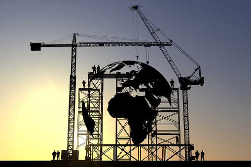 Globe icon construction site silhouette with cranes and steel structures