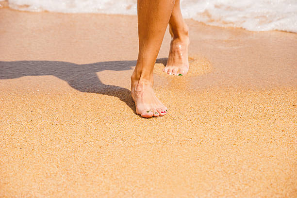 istock Female feet on the sand in the beach 585300108