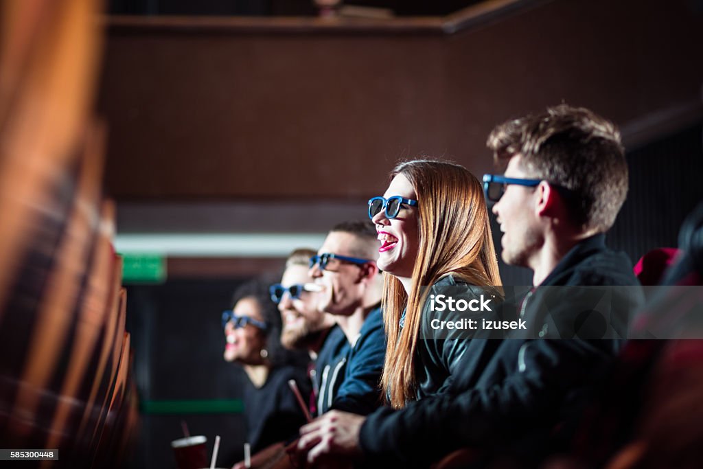 Group of young people in the 3D movie theater Group of happy young people in the 3D movie theater, watching comedy. Side view. Movie Theater Stock Photo
