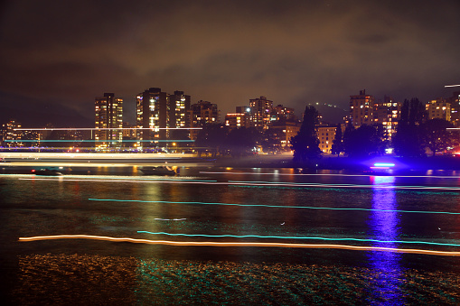 Streaks of light on Vancouver's False Creek after an evening of fireworks. Smoke hangs the air.