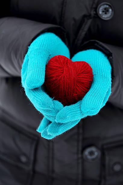 istock hands in knitted holding red heart 585302408