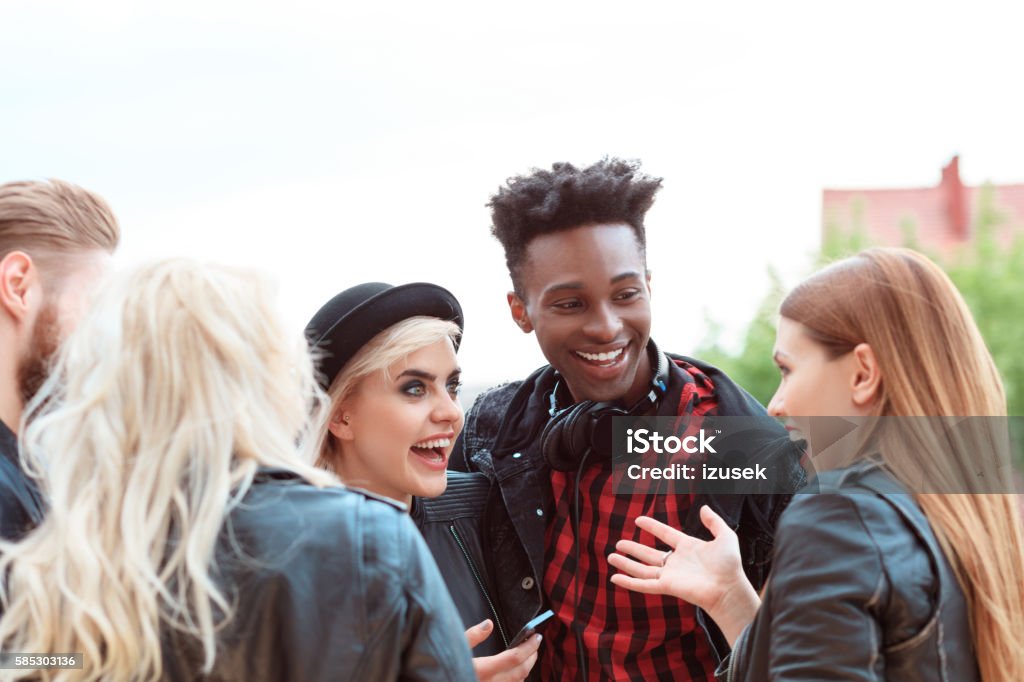 Happy friends in the city Multi ethnic group of young people talking outdoor in the city. 20-29 Years Stock Photo
