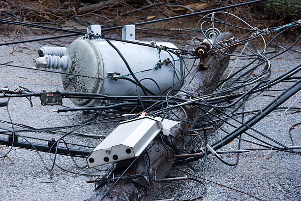 Electrical power outage due to heavy storm Tree falls after Nor-easter storm and takes down a telephone pole with Transformer. utility pole with power lines close up stock pictures, royalty-free photos & images
