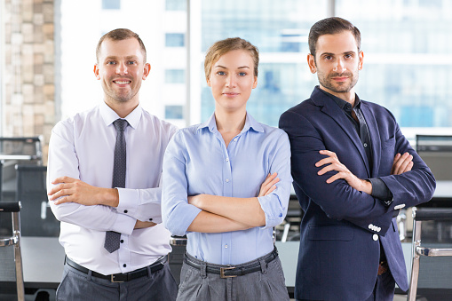 Group of successful business people standing with arms crossed and looking confident