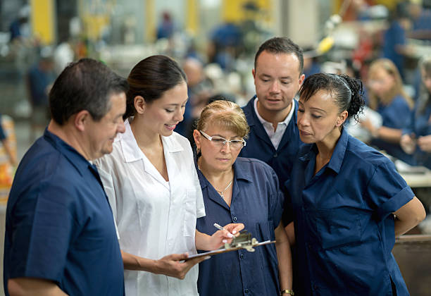 istock Supervisor talking to workers at a factory 585304858