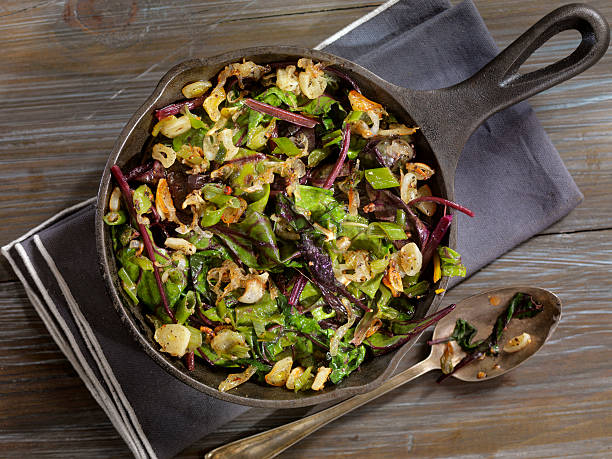 Beet Leaves Sautéed with Butter, Garlic and Onions Beet Leaves Sautéed with Butter, Garlic and Onions -Photographed on Hasselblad H3D2-39mb Camera cooking pan overhead stock pictures, royalty-free photos & images