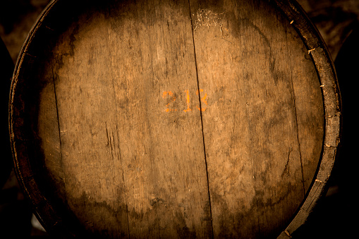 Wine barrels stacked in the old cellar of the winery.Detail.