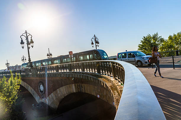 Bordeaux, France - July 19, 2016: Woman of African ethnicity walking to work during the morning commute at Pont de Pierre, Bordeaux. The tram and cycle networks throughout the city centre contribute to a more relaxed atmosphere than most other big cities.