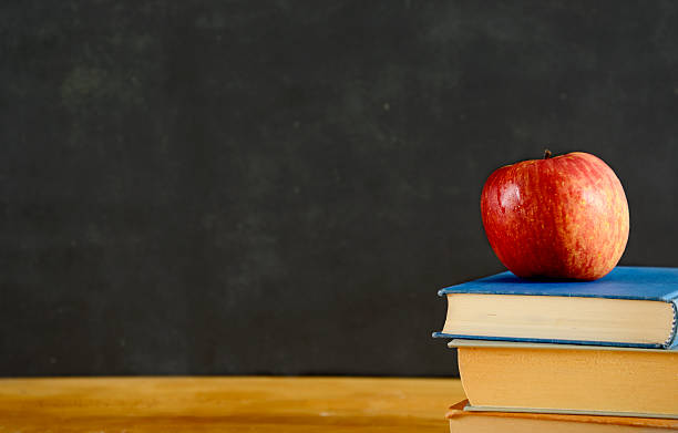istock Red Apple and books on desk. Copy Space. 585309460