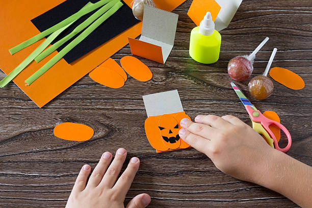 istock The child create a greeting packaging for lollipop on Halloween 585313278