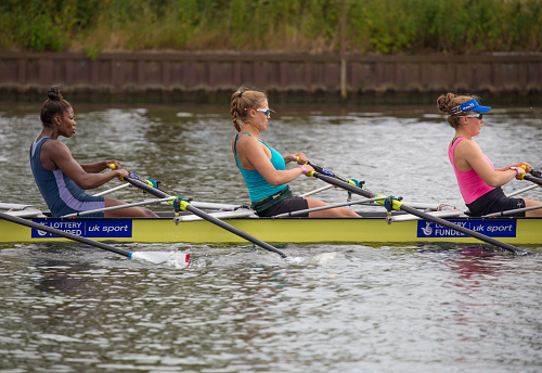Group of rowing team athletes sculling during competition, kayak boats race in a rowing canal, regatta in a summer day, canoeing water sports team training in a river