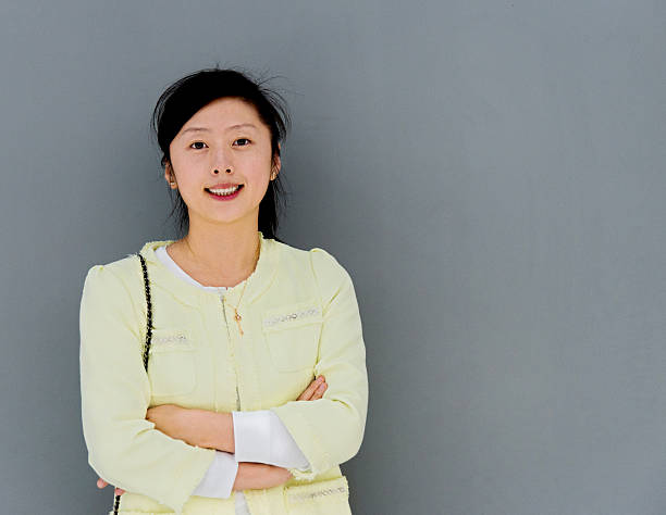istock Young woman smiling against gray wall 585313676