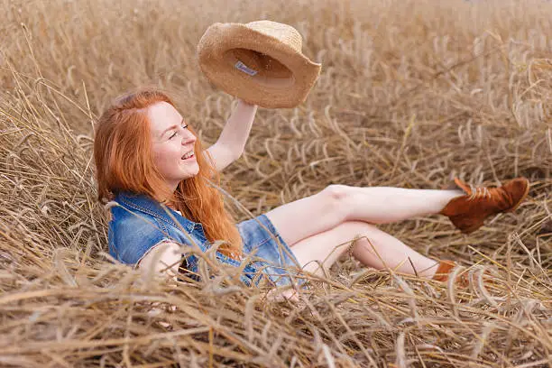 redhair beautiful country girl lies in hay